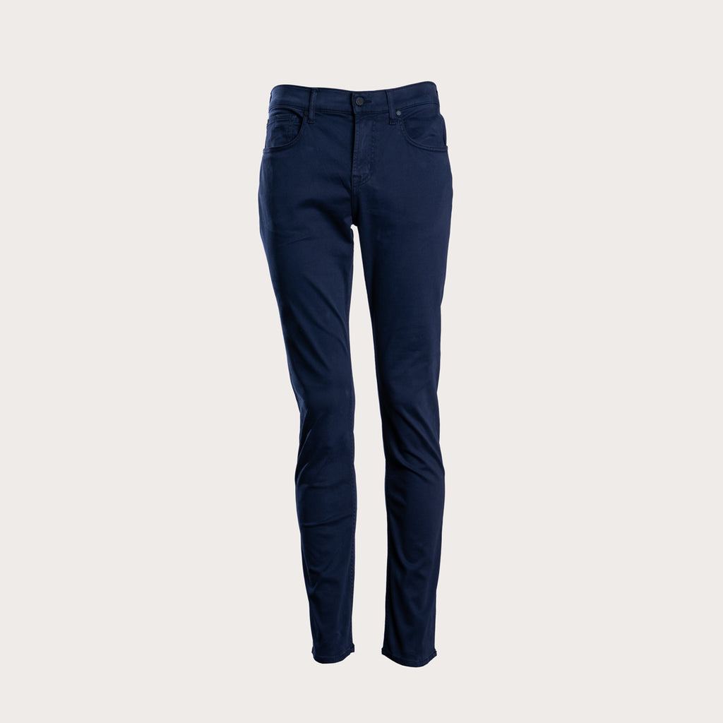A pair of dark navy blue slim-fit jeans shown on a headless mannequin form against a solid light beige background. 7 For All Mankind Slimmy Sateen Jeans. Sakks Menswear Southampton.