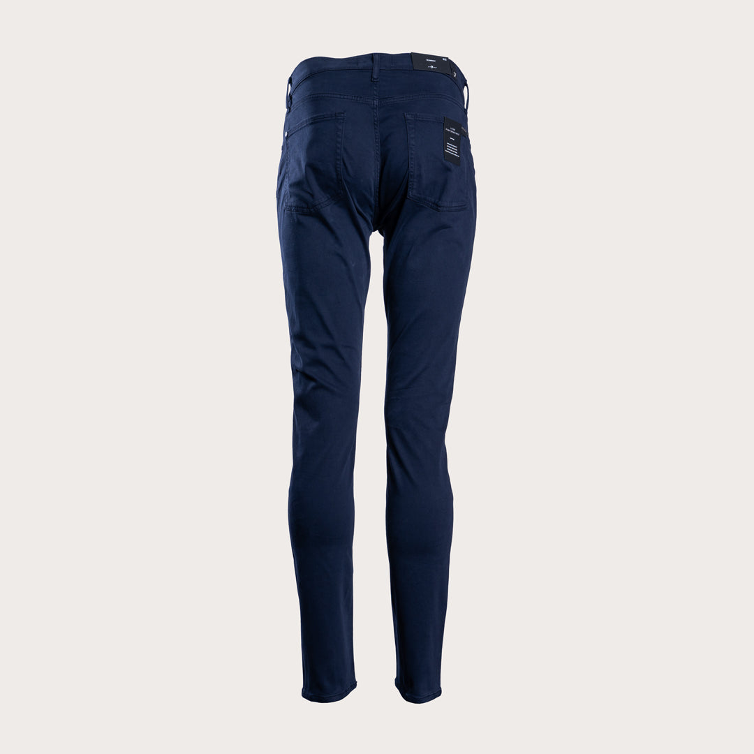 A pair of dark navy blue slim-fit jeans shown on a headless mannequin form against a solid light beige background. 7 For All Mankind Slimmy Sateen Jeans. Sakks Menswear Southampton.
