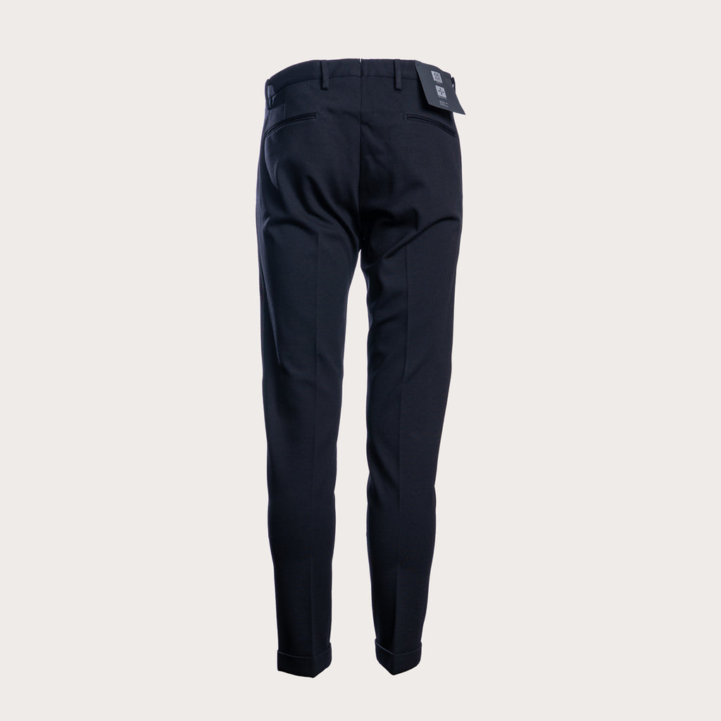 A pair of dark navy trousers shown from the back, featuring a slim fit and a small brand patch near the waistband, set against a solid light gray background. Briglia 1949 Trousers available at Sakks Menswear in Southampton.