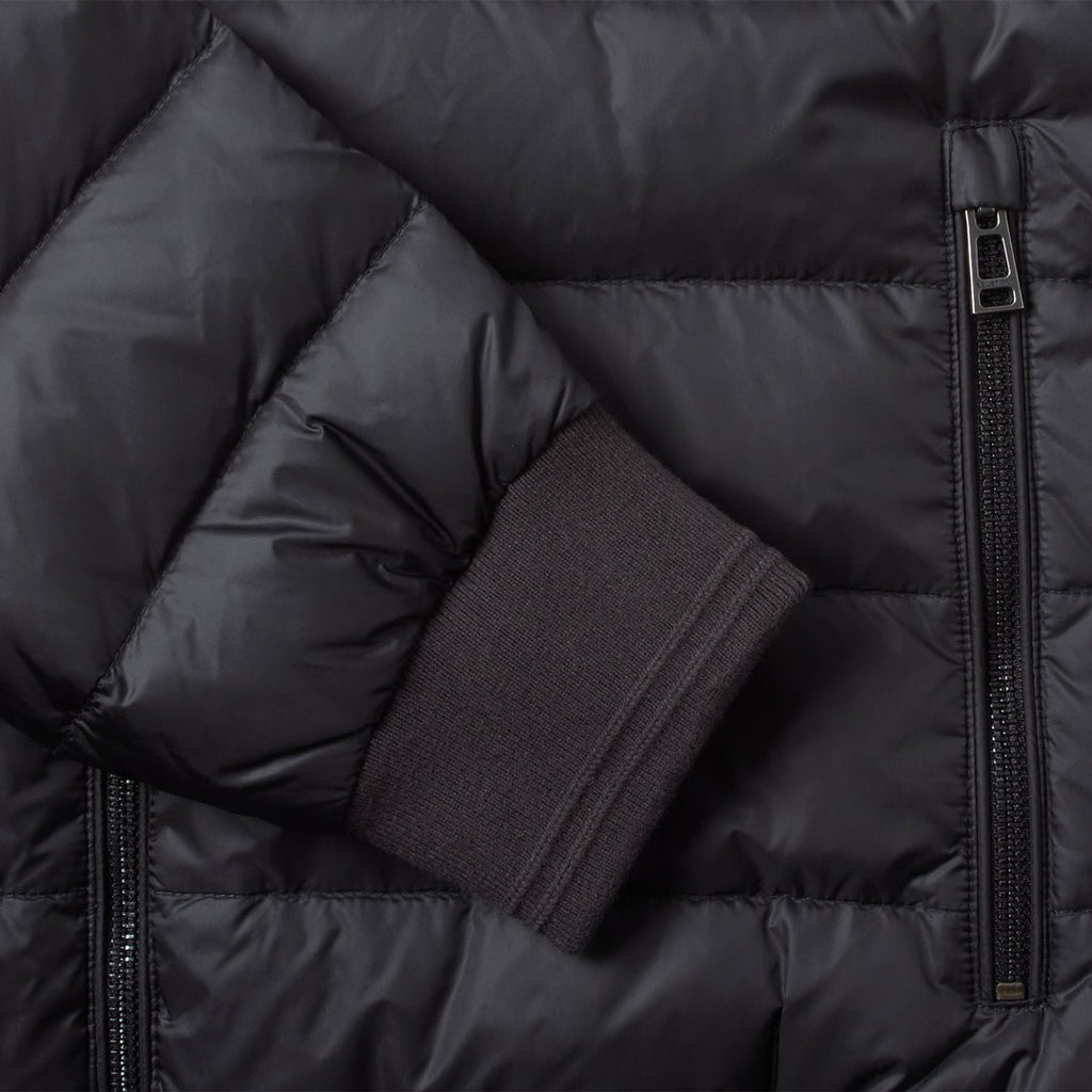 Close-up of a black puffer jacket showing quilted padding, a side zipper, and a ribbed dark cuff. Belstaff Down Jacket. Sakks Menswear Southampton.