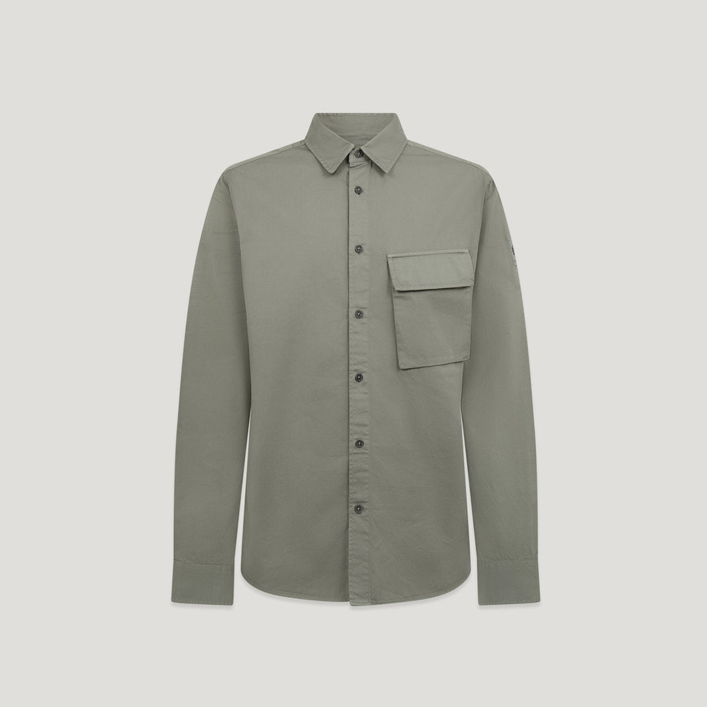 A long-sleeve button-up shirt in a muted sage green color, featuring a single chest pocket and dark buttons, displayed against a solid light gray background. Belstaff Shirt. Sakks Menswear Southampton.