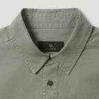 Close-up of a light sage green collared shirt by Belstaff, showing the inner neck label with the brand name and logo. Belstaff Shirt. Sakks Menswear Southampton.