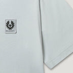 Close-up of a light gray short-sleeve T-shirt with a square Belstaff logo patch on the chest and a visible hem seam. Belstaff T-Shirt. Sakks Menswear Southampton.