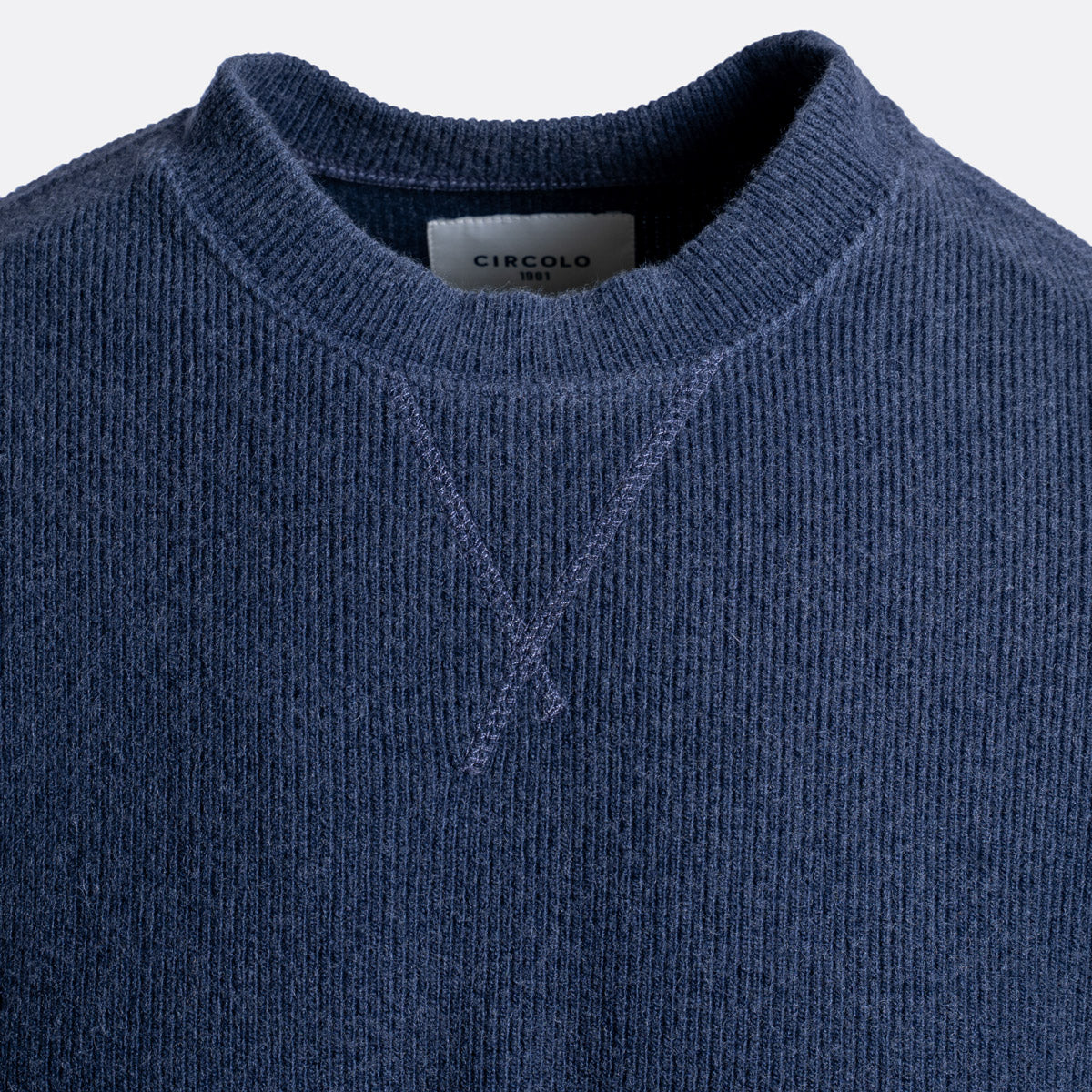 Close-up of a navy blue knit crewneck sweater with a visible neck label reading CIRCOLO. Circolo 1901 Jumper available at Sakks Menswear in Southampton.