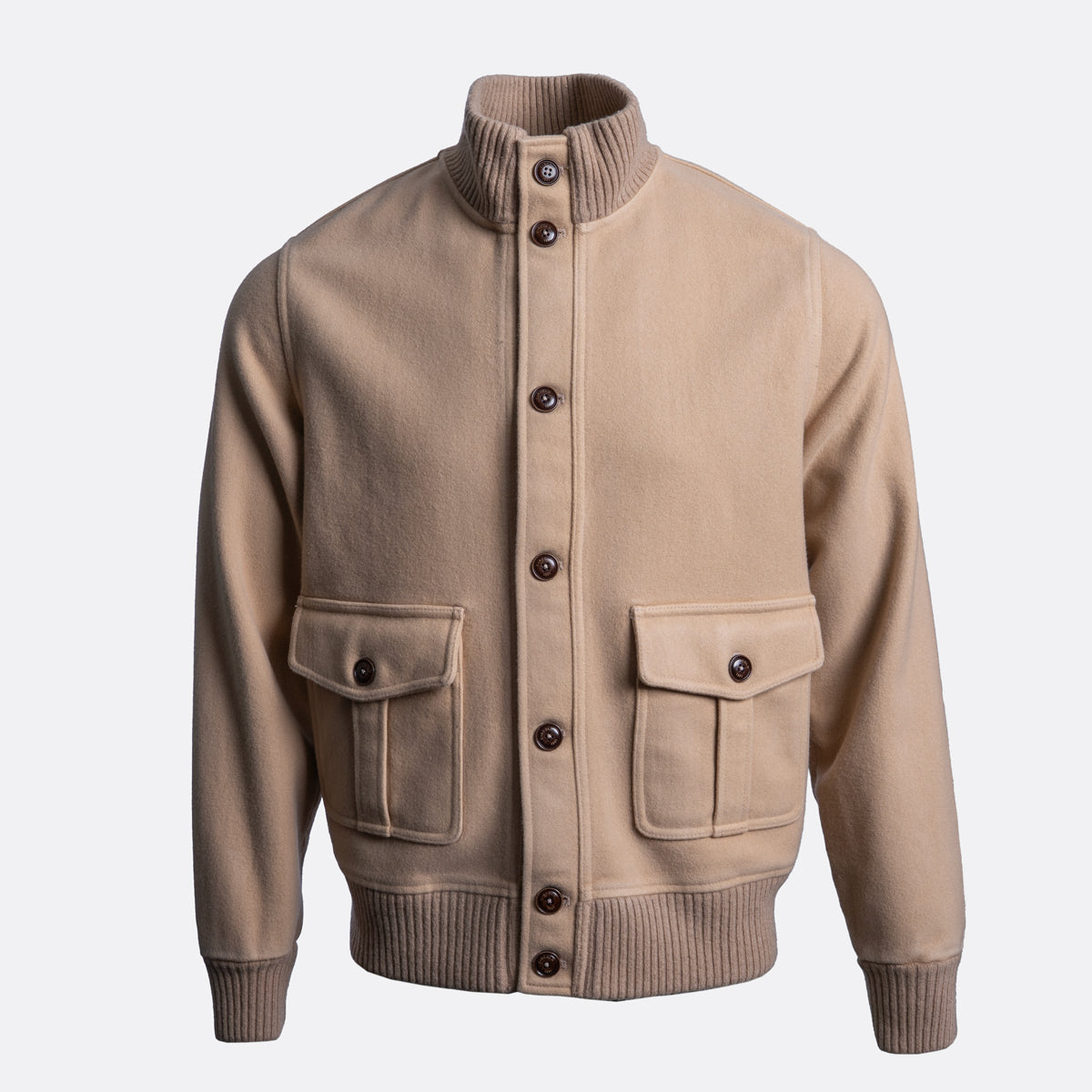 A beige knit jacket with a ribbed mock neck, button front, and two front flap pockets, shown on a light gray background. Circolo 1901 Jacket available at Sakks Menswear in Southampton.