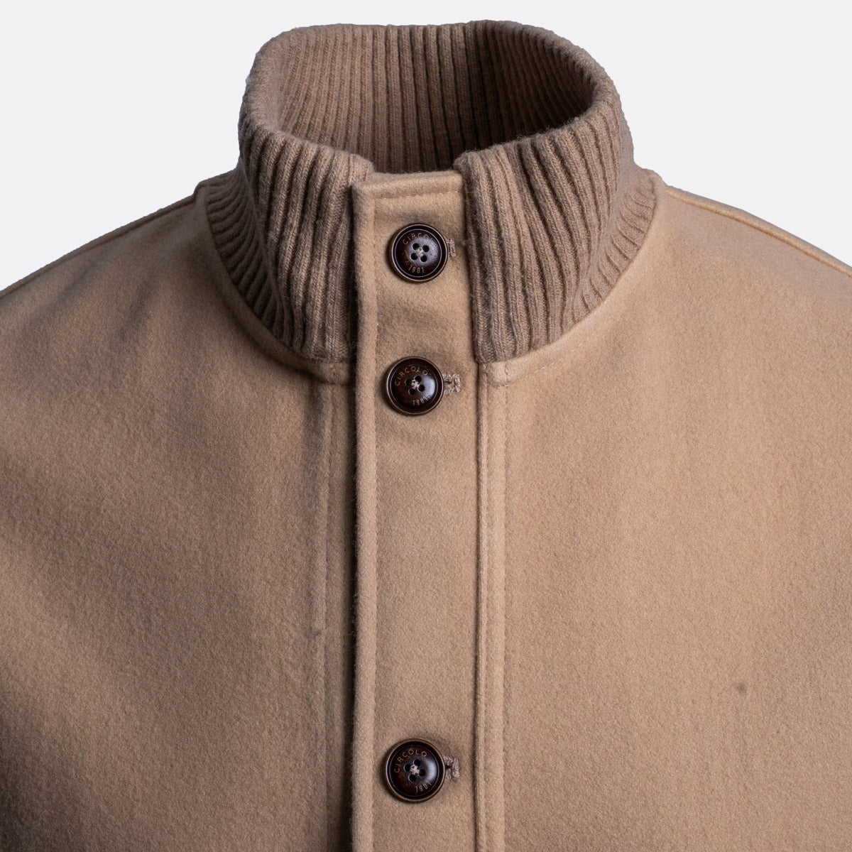 Close-up of a tan wool-blend jacket with a ribbed brown mock neck collar and three dark brown buttons down the front placket. Circolo 1901 Jacket available at Sakks Menswear in Southampton.
