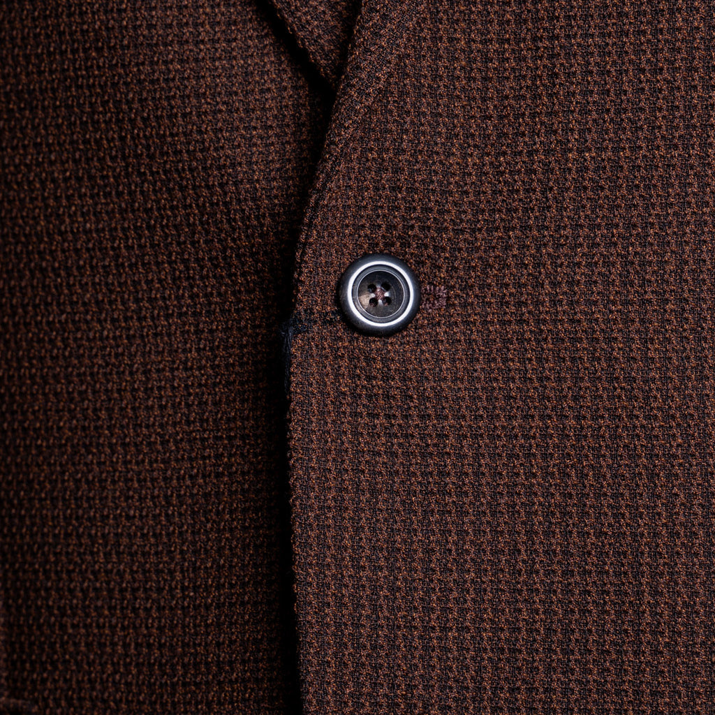 Close-up of a textured brown knit fabric garment, showing the weave and a single dark button. Circolo 1901 Blazer available at Sakks Menswear in Southampton.