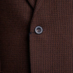 Close-up of a textured brown knit fabric garment, showing the weave and a single dark button. Circolo 1901 Blazer available at Sakks Menswear in Southampton.