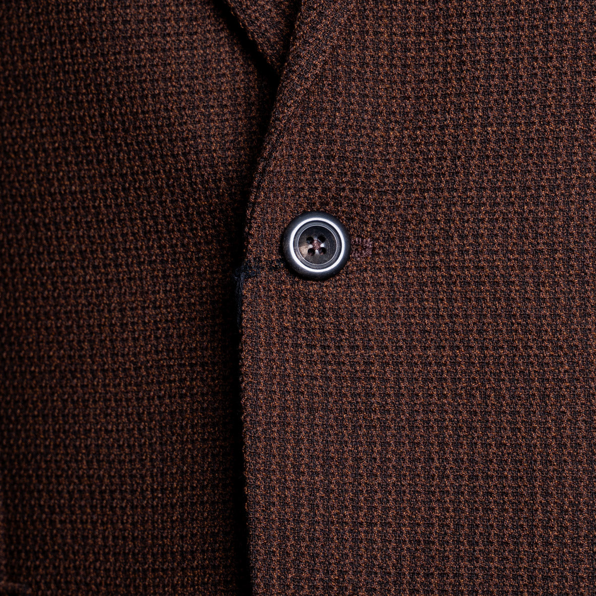 Close-up of a textured brown knit fabric garment, showing the weave and a single dark button. Circolo 1901 Blazer available at Sakks Menswear in Southampton.