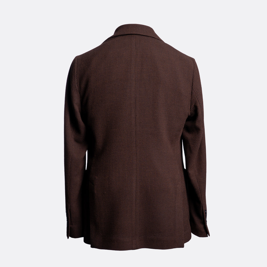 A dark brown textured blazer shown from the back, featuring a subtle vertical rib pattern and notch lapels, set against a plain light gray background. Circolo 1901 Blazer available at Sakks Menswear in Southampton.
