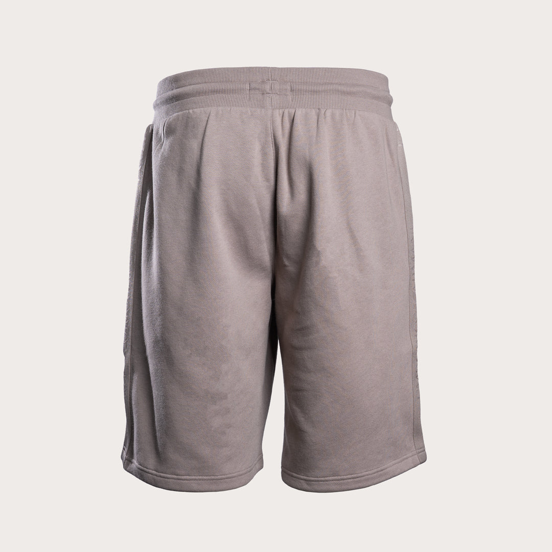 A pair of light taupe gray athletic shorts with a ribbed elastic waistband, shown from the back on a light beige background. Emporio Armani Sweat Shorts. Sakks Menswear Southampton.
