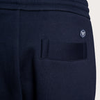 Close-up of navy blue sweatpants showing the back pocket with a hook-and-loop closure and a small embroidered shield logo on the upper back. Emporio Armani Sweat Pants. Sakks Menswear Southampton.