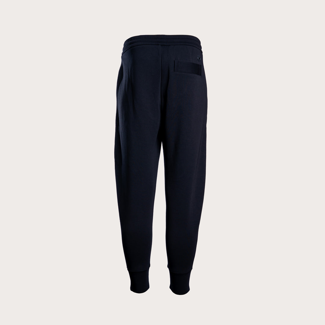 Dark navy blue sweatpants shown from the back, featuring a drawstring waistband, a side pocket, and ribbed cuffs, displayed on a light gray background. Emporio Armani Sweat Pants. Sakks Menswear Southampton.