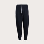 A pair of dark navy jogger sweatpants with a white drawstring, displayed on a clean, light beige background. Emporio Armani Sweat Pants. Sakks Menswear Southampton.