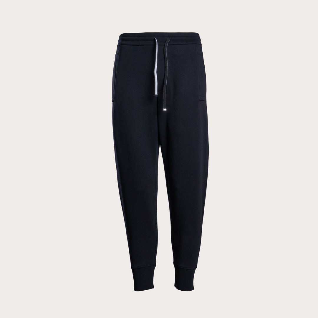 A pair of dark navy jogger sweatpants with a white drawstring, displayed on a clean, light beige background. Emporio Armani Sweat Pants. Sakks Menswear Southampton.
