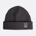 A dark gray ribbed knit beanie hat with a folded cuff and a small square patch featuring the Emporio Armani eagle logo, shown against a light gray background. Emporio Armani Beanie. Sakks Menswear Southampton.