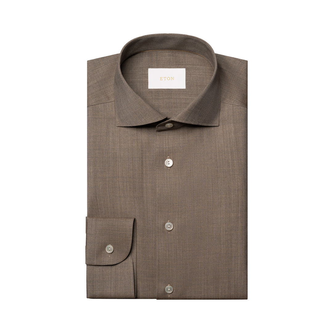 A folded brown dress shirt with a spread collar and button-down front, displayed on a clean white background. Eton Shirt available at Sakks Menswear in Southampton.