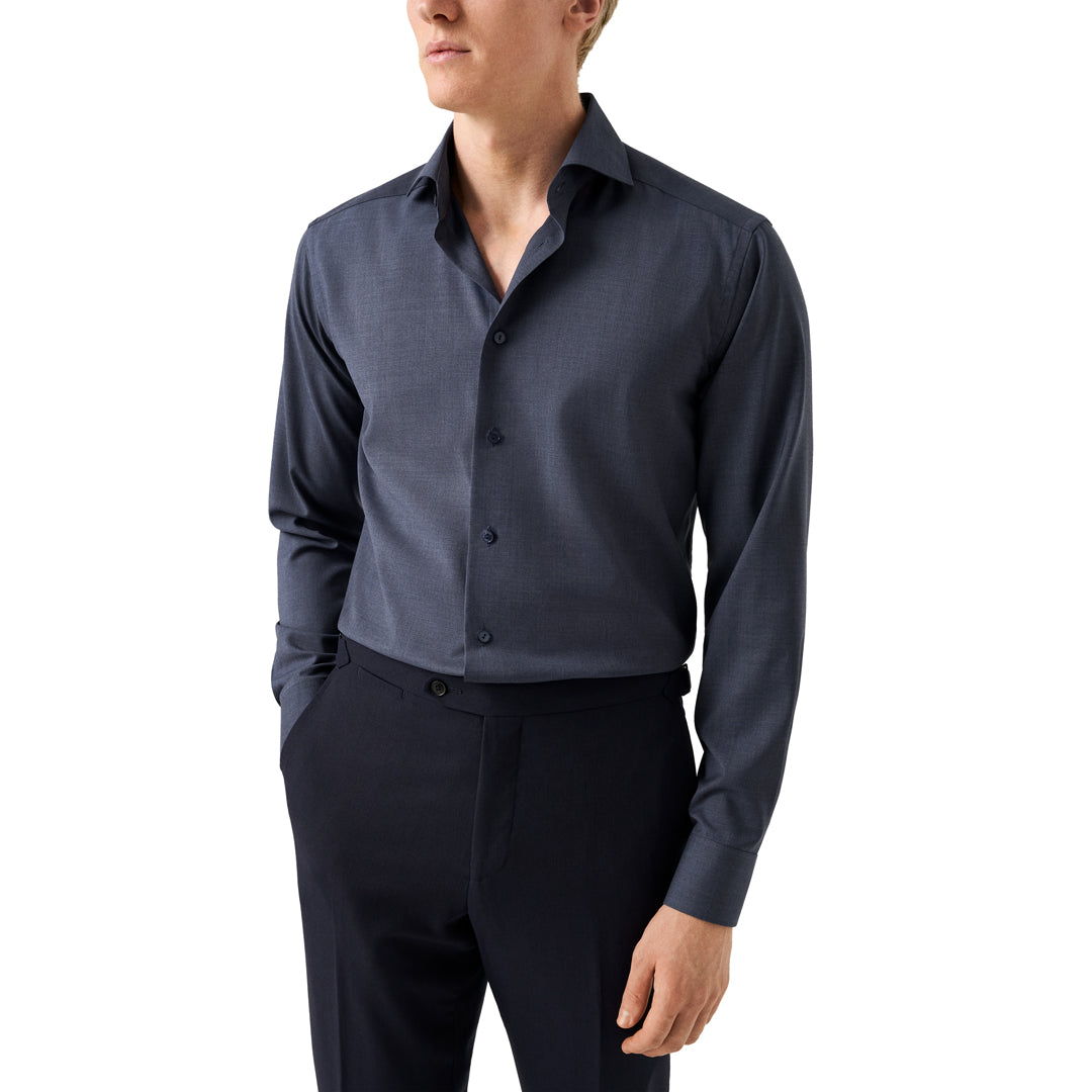 Person wearing a dark blue dress shirt and black pants on a white background. Eton Shirt available at Sakks Menswear in Southampton.