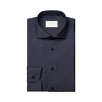 A folded dark navy blue dress shirt with a spread collar and button front, shown on a plain white background. A small white neck label is visible inside the collar. Eton Shirt available at Sakks Menswear in Southampton.