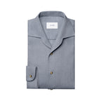 A folded light gray long-sleeve shirt with a spread collar and brass buttons, featuring a visible ETON brand label inside the collar, set against a plain white background. Eton Shirt available at Sakks Menswear in Southampton.