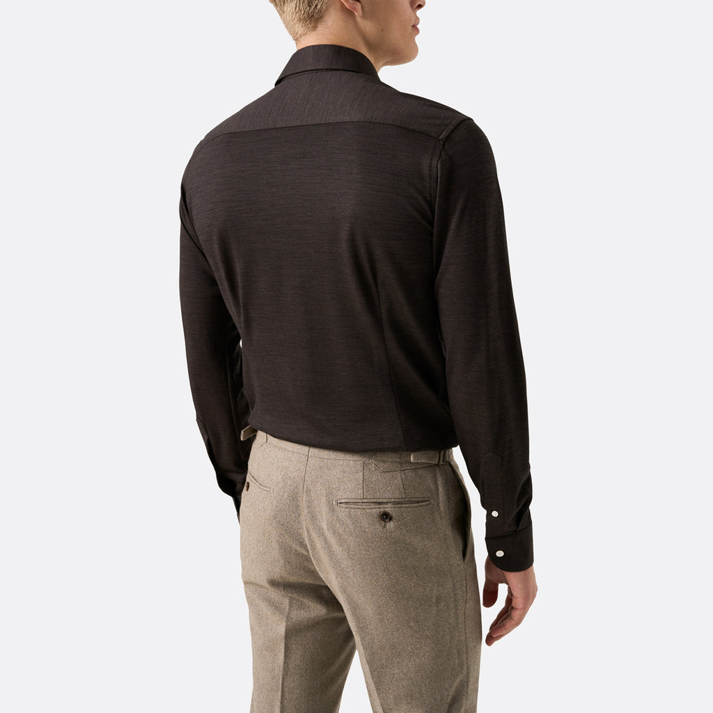 A man shown from the back wearing a dark brown long-sleeve knit button-down shirt and light beige trousers, against a light gray studio background. Eton Shirt available at Sakks Menswear in Southampton.