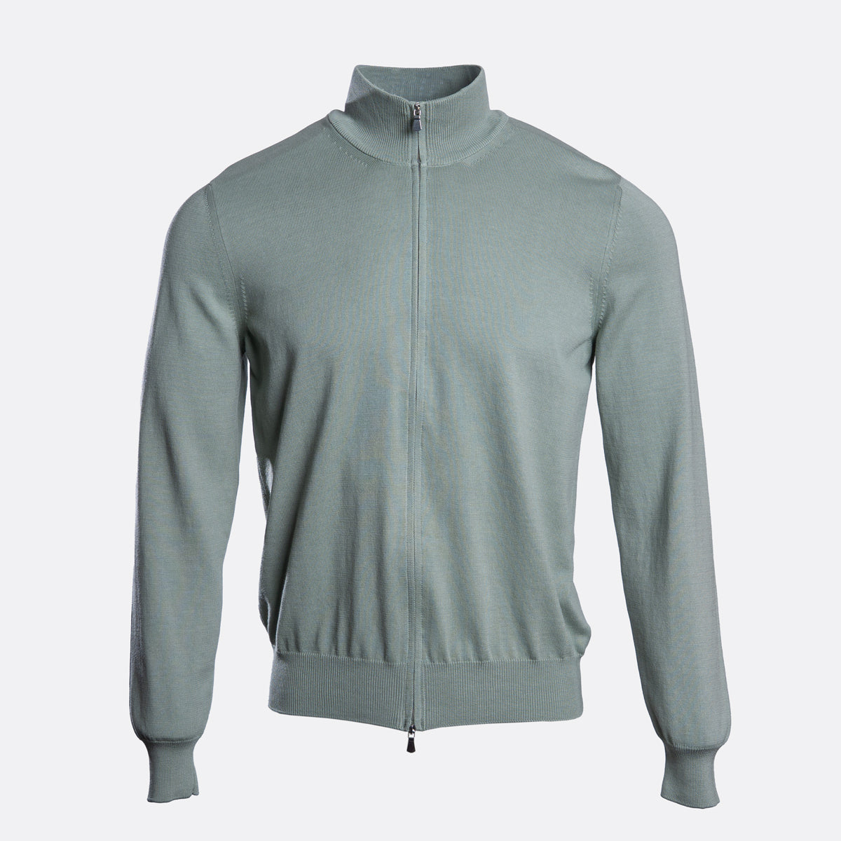 A light sage green knit zip-up jacket with a mock neck collar, shown on a clean, light grey background. Gran Sasso Knitwear available at Sakks Menswear in Southampton.