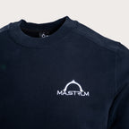 Close-up of a dark navy crewneck sweatshirt featuring a white printed 'MASTRUM' logo on the left chest, set against a light beige background. MA.Strum Sweatshirt available at Sakks Menswear in Southampton.