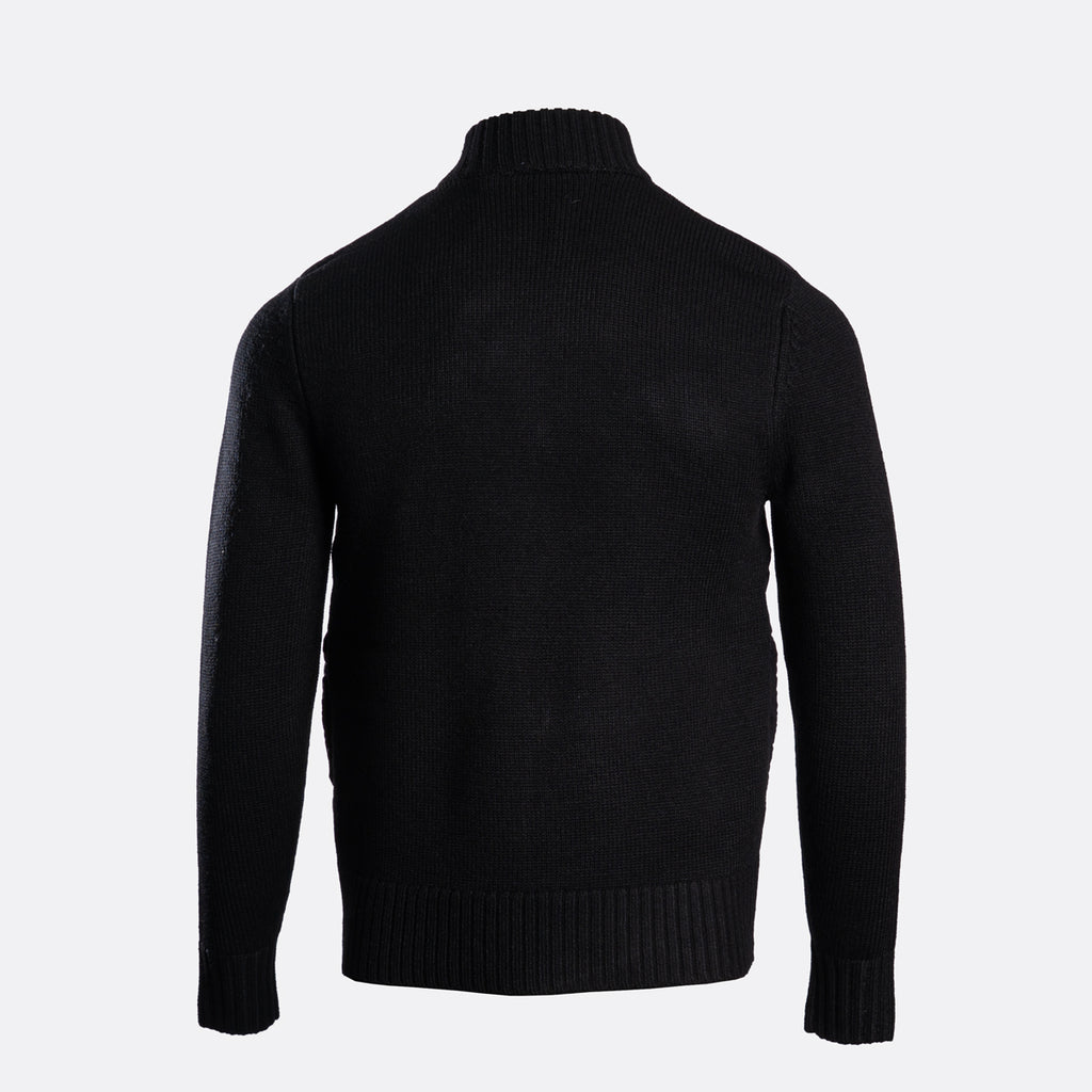 A black ribbed knit turtleneck sweater shown from the back on a light gray background. MA.Strum Hybrid Jacket available at Sakks Menswear in Southampton.