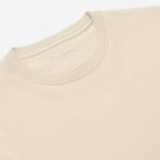 Close-up of a light beige crewneck t-shirt showing the inner collar label with 'Oliver Sempéy' printed in gray. Oliver Sweeney T-Shirt available at Sakks Menswear in Southampton