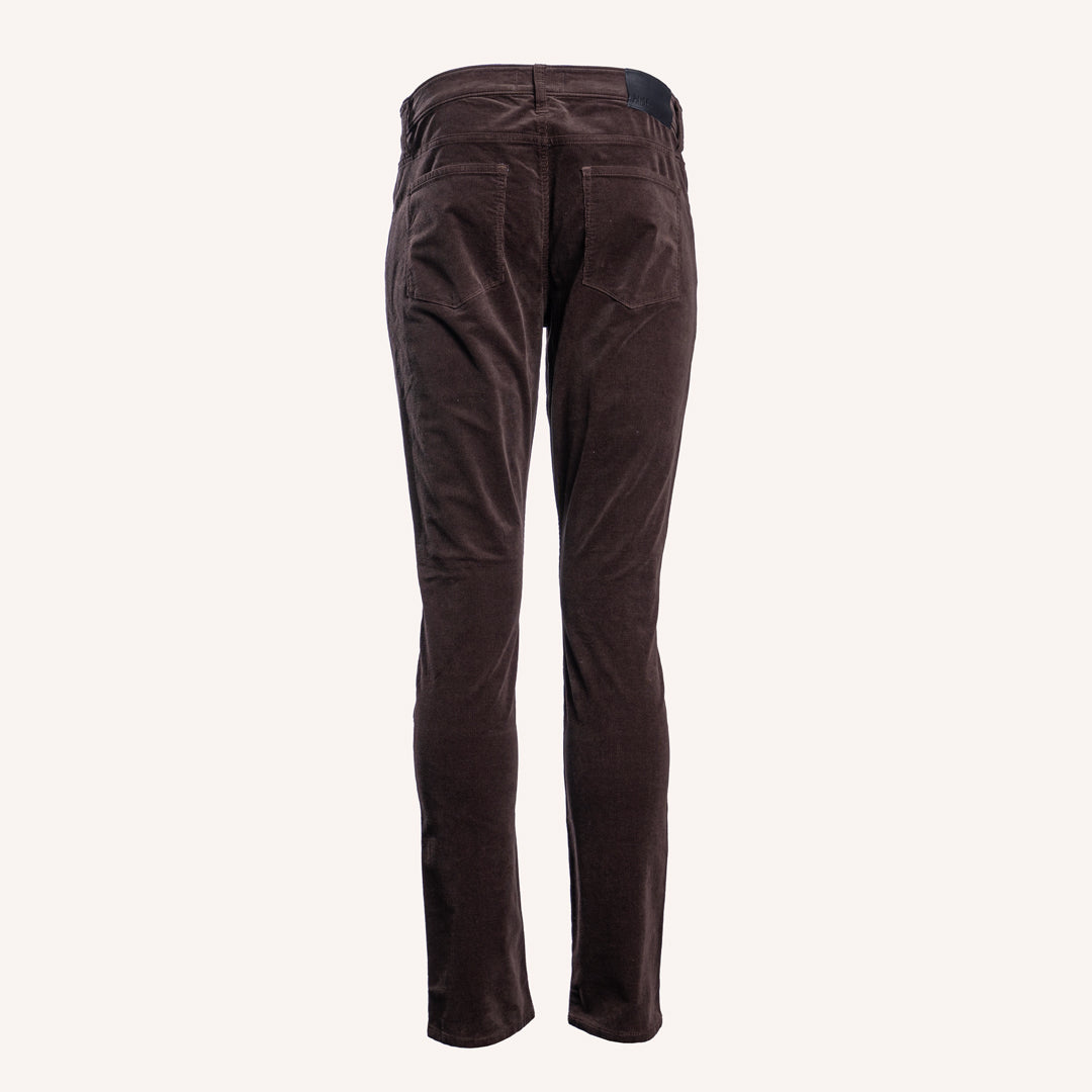 Dark brown corduroy trousers shown from the back, featuring a button waistband and back pockets, set against a solid off-white background. PAIGE Jeans available at Sakks Menswear in Southampton.