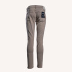 A pair of slim-fit jeans in a taupe-brown color, shown from the back on a light cream background. A black brand label is visible on the back right pocket. PAIGE Jeans available at Sakks Menswear in Southampton.