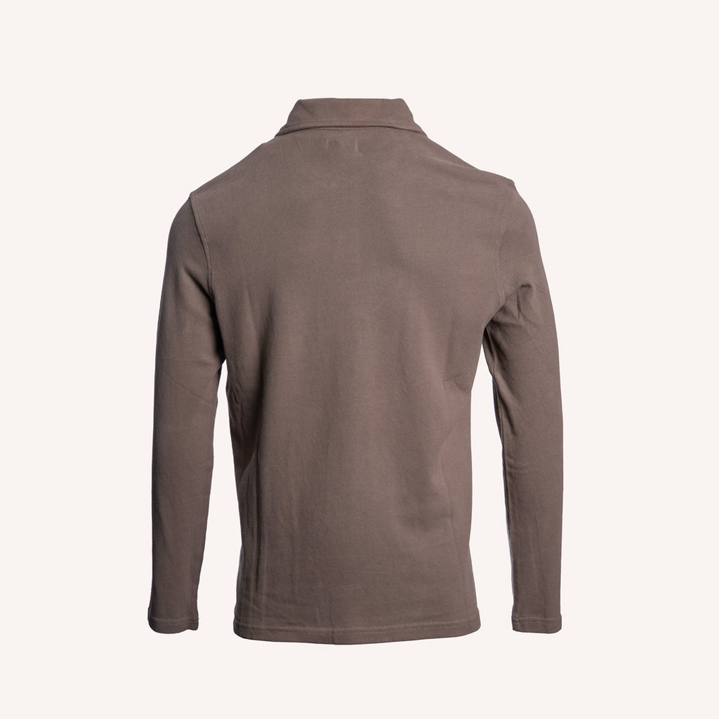 A long-sleeve polo shirt shown from the back, in a solid taupe-brown color, displayed on a clean off-white background. PAIGE Polo available at Sakks Menswear in Southampton.