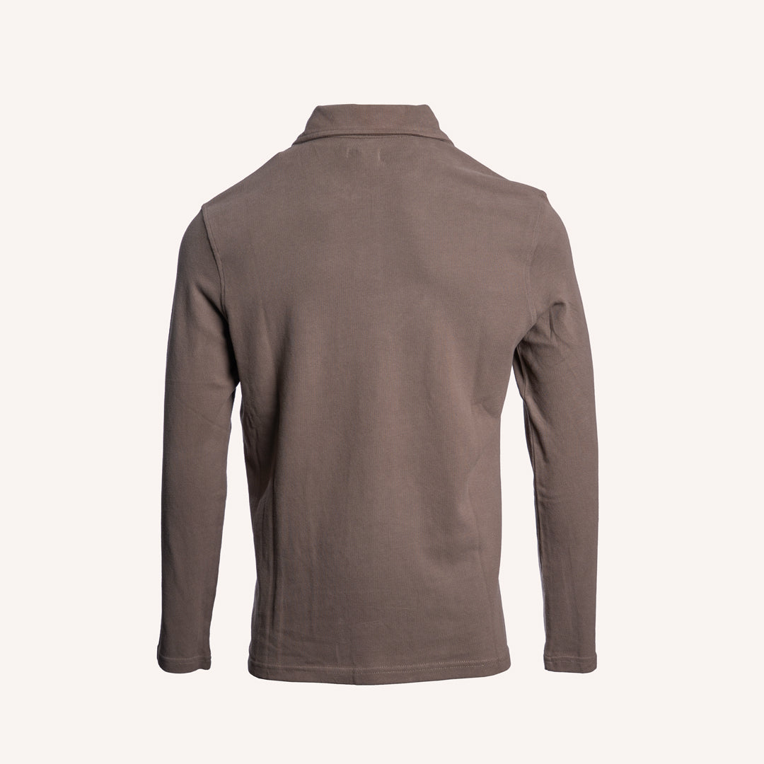 A long-sleeve polo shirt shown from the back, in a solid taupe-brown color, displayed on a clean off-white background. PAIGE Polo available at Sakks Menswear in Southampton.