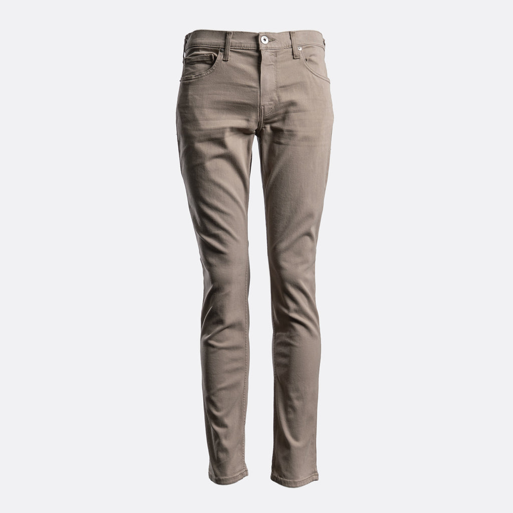 A pair of slim-fit jeans in a muted taupe-brown color, shown on a clean, light gray background. PAIGE Jeans available at Sakks Menswear in Southampton.