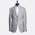 A light gray and white checkered blazer jacket displayed on a black mannequin torso with a white dress shirt underneath, set against a plain light gray background. Sand Copenhagen Blazer available at Sakks Menswear in Southampton.