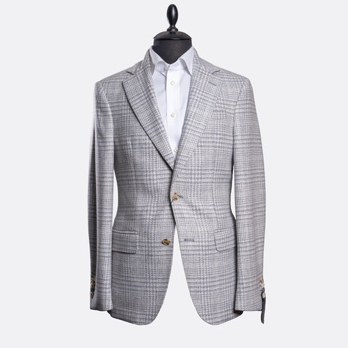 A light gray and white checkered blazer jacket displayed on a black mannequin torso with a white dress shirt underneath, set against a plain light gray background. Sand Copenhagen Blazer available at Sakks Menswear in Southampton.