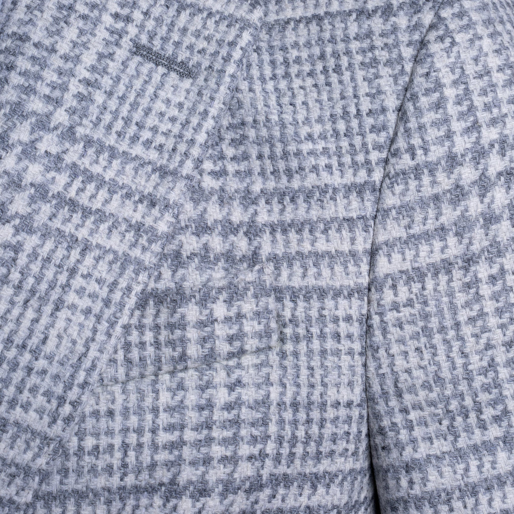 Close-up of a textured fabric with a small-scale blue and white houndstooth pattern. Sand Copenhagen Blazer available at Sakks Menswear in Southampton.