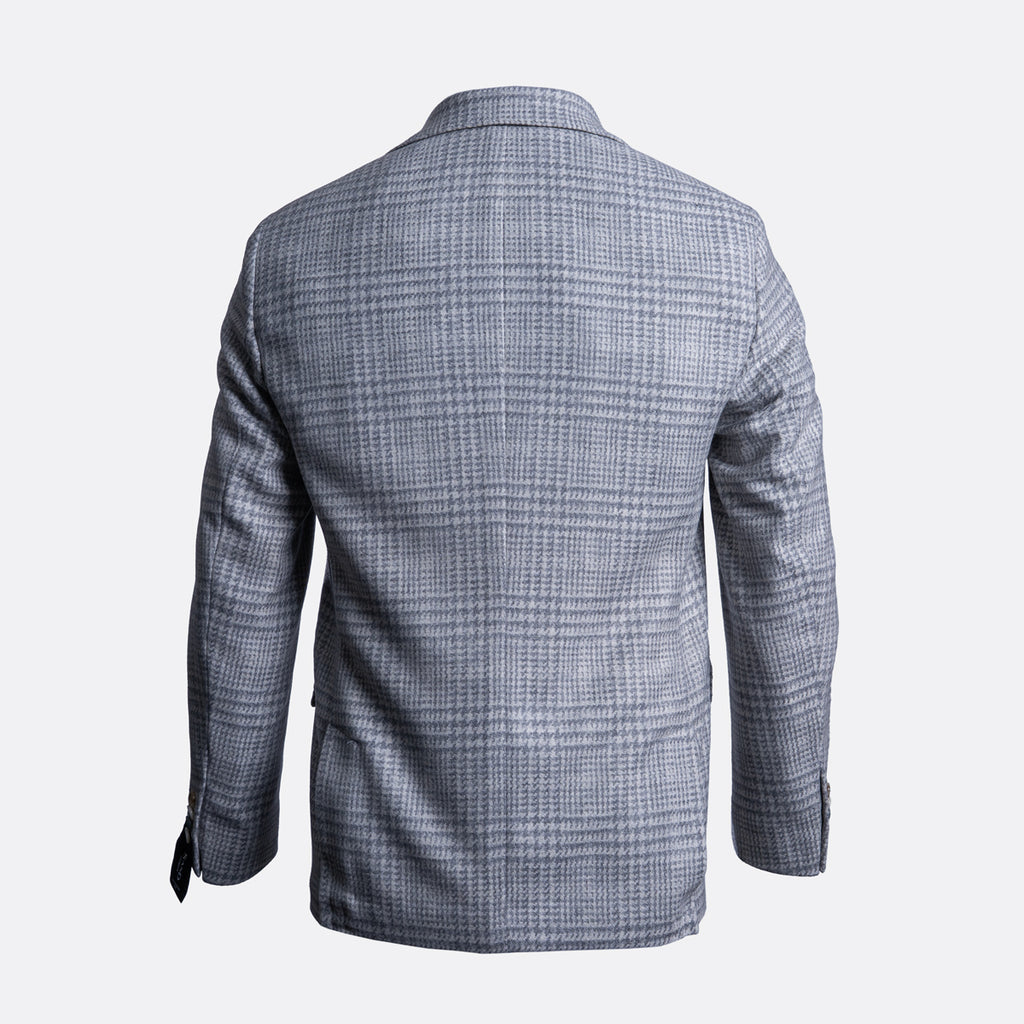 The back view of a men's blazer in a gray and white windowpane plaid pattern, displayed on a clean light gray background. Sand Copenhagen Blazer available at Sakks Menswear in Southampton.