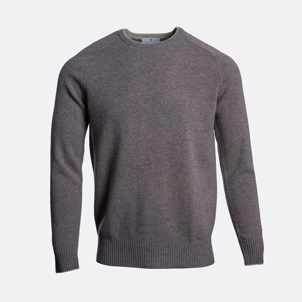 A dark gray heather knit crewneck sweater with raglan sleeves and ribbed cuffs and hem, shown on a light gray background. Thomas Maine Jumper available at Sakks Menswear in Southampton.