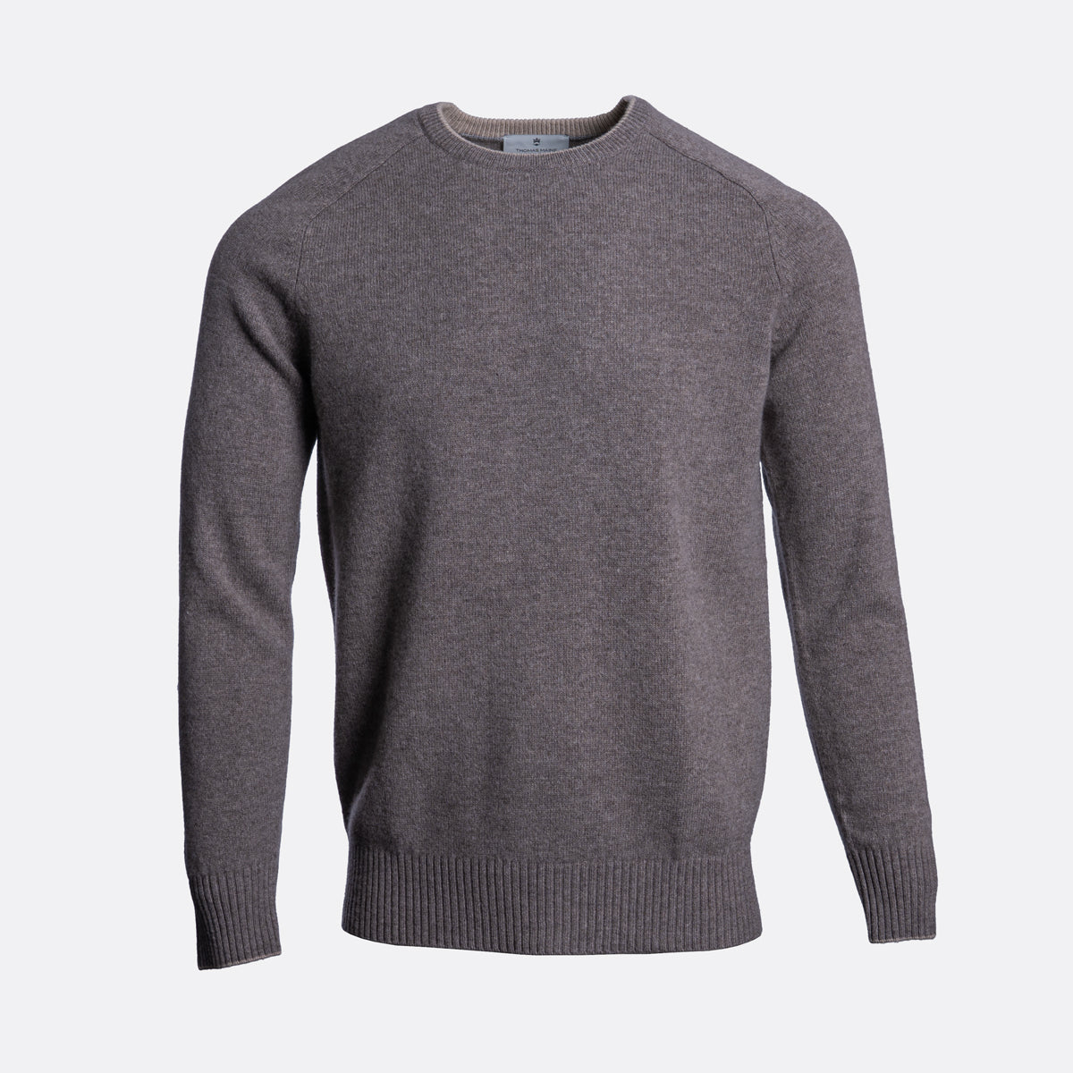 A dark gray heather knit crewneck sweater with raglan sleeves and ribbed cuffs and hem, shown on a light gray background. Thomas Maine Jumper available at Sakks Menswear in Southampton.