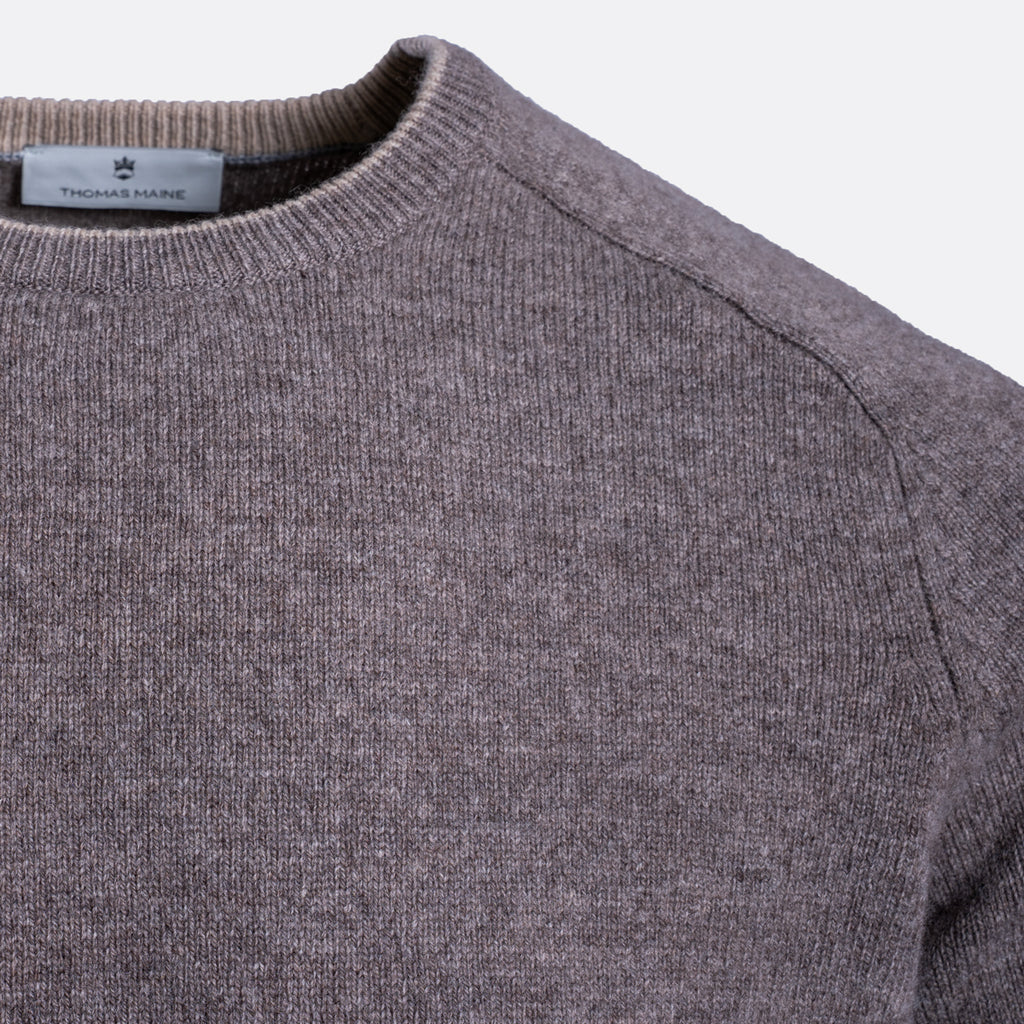 Close-up of a ribbed knit crewneck sweater in a heathered taupe-gray color, showing the inner neck label with the brand name 'Tweedmill'. Thomas Maine Jumper available at Sakks Menswear in Southampton.