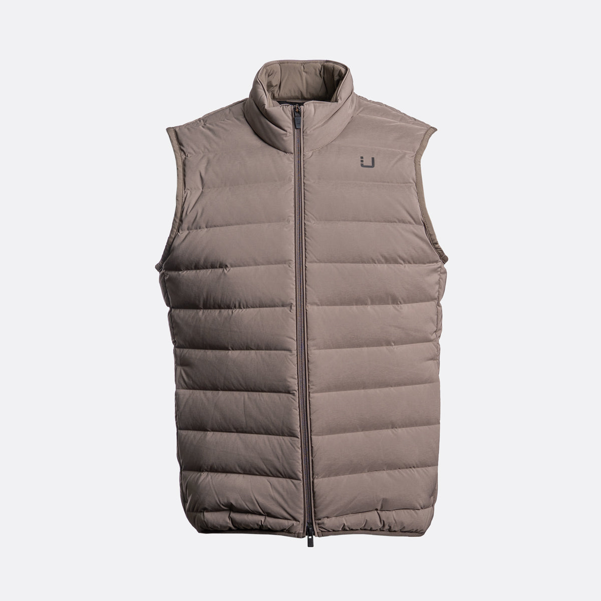 A sleeveless, quilted puffer vest in a taupe-brown color, featuring a full-length front zipper and a small dark logo on the left chest, displayed against a light gray background. UBR Gilet available at Sakks Menswear in Southampton.