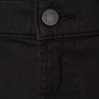 Close-up of black denim pants showing the button closure with a silver-toned button that reads '7 For All Mankind'.  7 For All Mankind Chinos available at Sakks Menswear in Southampton.