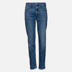 A pair of medium wash blue denim jeans shown flat against a light gray background. 7 For All Mankind jeans available at Sakks Menswear in Southampton.