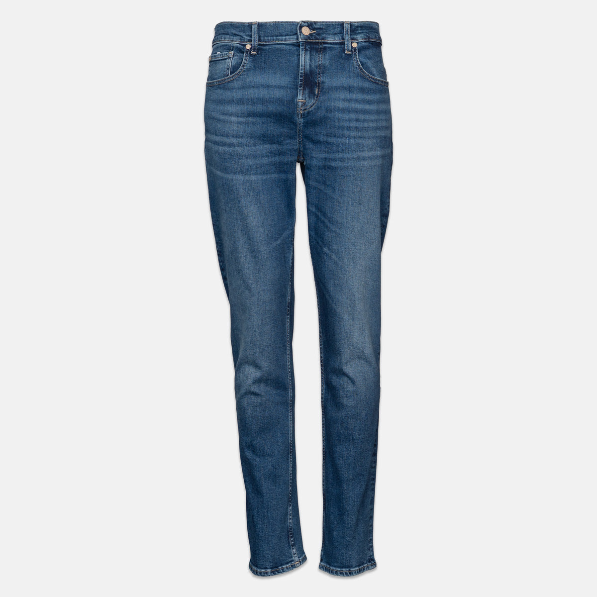 A pair of medium wash blue denim jeans shown flat against a light gray background. 7 For All Mankind jeans available at Sakks Menswear in Southampton.