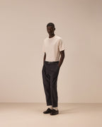 Model wearing a off white coloured tshirt tucked in to a pair of dark brown trousers and black shoes. Model is stood with his hands in his pockets in front of a off white coloured studio backdrop.  Circolo 1901 T-Shirt available at Sakks Menswear in Southampton.
