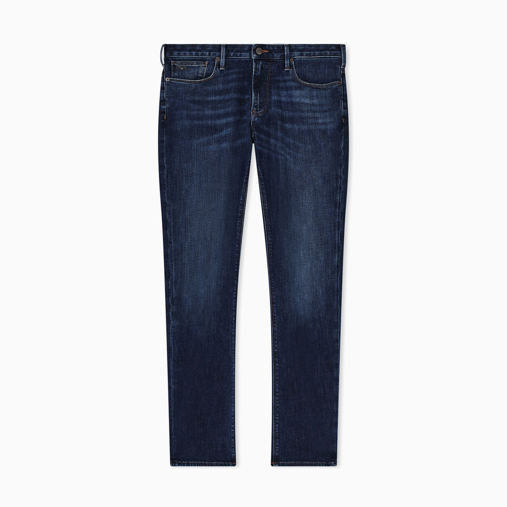 A pair of dark blue slim-fit jeans with subtle whiskering and fading on the thighs, shown flat against a solid white background. Emporio Armani Jeans available at Sakks Menswear in Southampton.