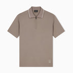 A taupe short-sleeve polo shirt with a half-zip collar and white piping trim, shown flat against a light gray background. Emporio Armani olo available at Sakks Menswear in Southampton.