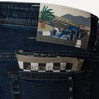 Close-up of the back pocket of dark blue denim jeans showing the back pocket label with a checkered black and white stripe pattern and the embroidered brand patch. Jacob Cohen Jeans available at Sakks Menswear in Southampton.