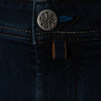 Close-up detail of dark indigo denim jeans showing the button closure, contrast stitching, and a small blue and brown brand tab. Jacob Cohen Jeans available at Sakks Menswear in Southampton.